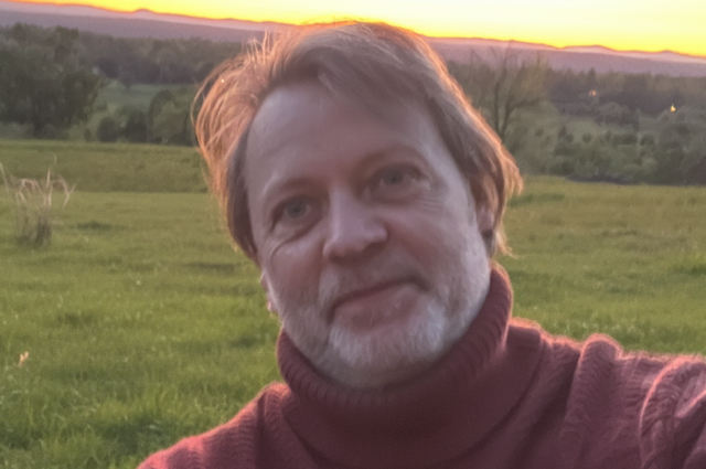 Hiker walking across mountain summit