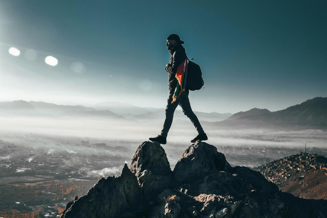 Hiker walking across mountain summit